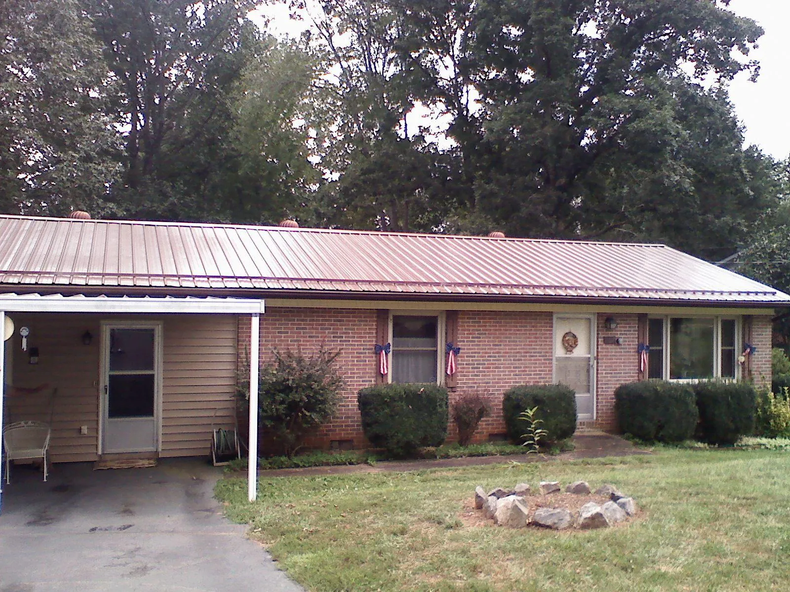 Bronze metal roof and carport on a brick ranch home — Roof Repair work by our crew in Santa Fe