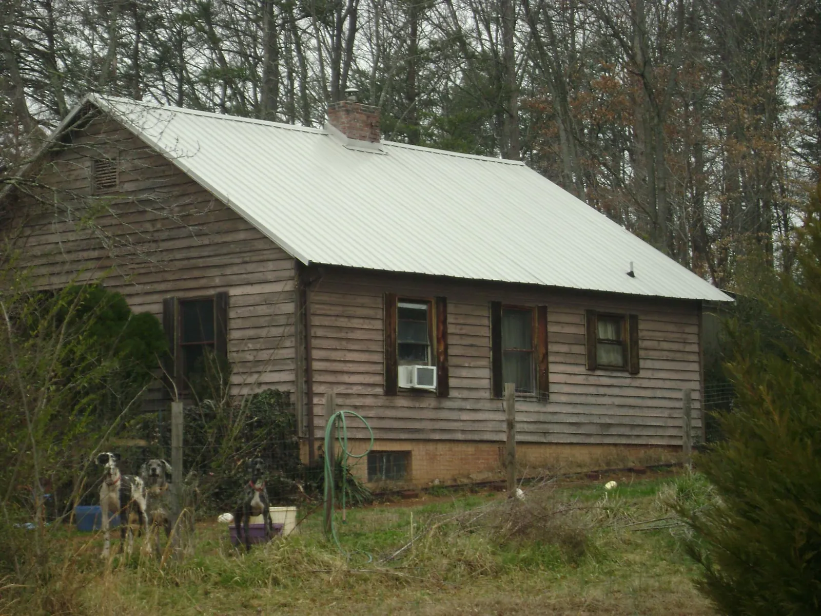 White metal roof on an old wood sided farmhouse, from a Asphalt Shingle Roof Repair job in Santa Fe